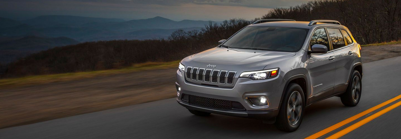 2019 Jeep Cherokee driving through foothills at dusk